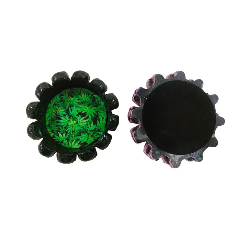 Round black ashtrays with scalloped edges, one showing green cannabis leaf design inside
