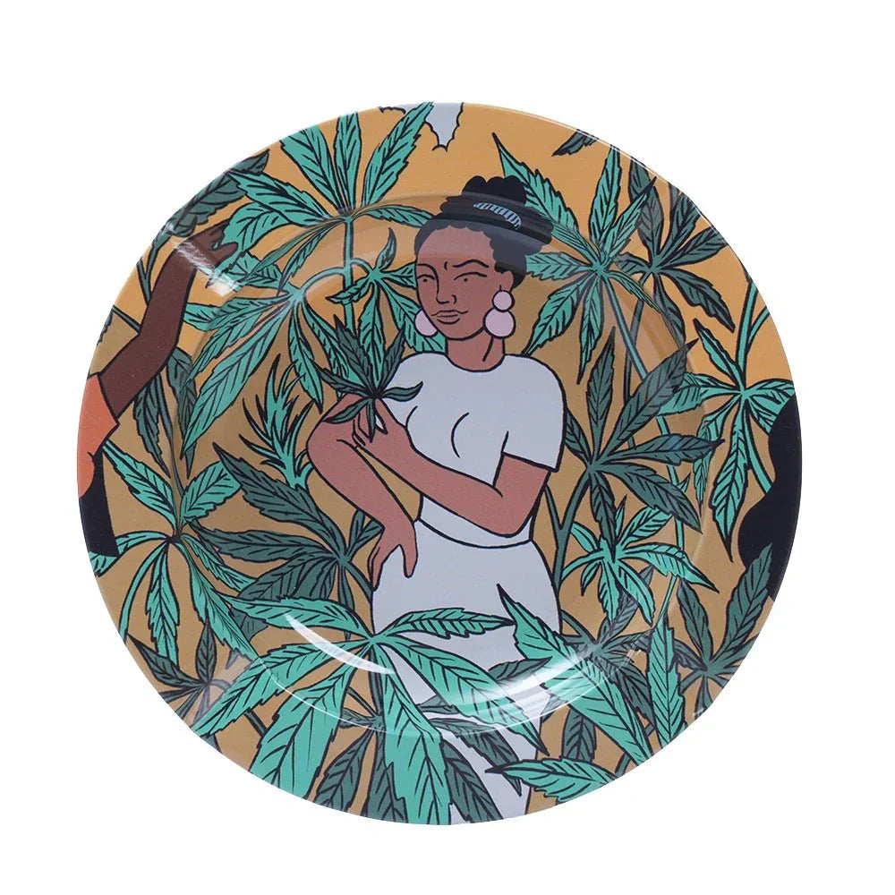 Round ashtray with illustration of woman in white dress surrounded by green cannabis leaves on yellow background