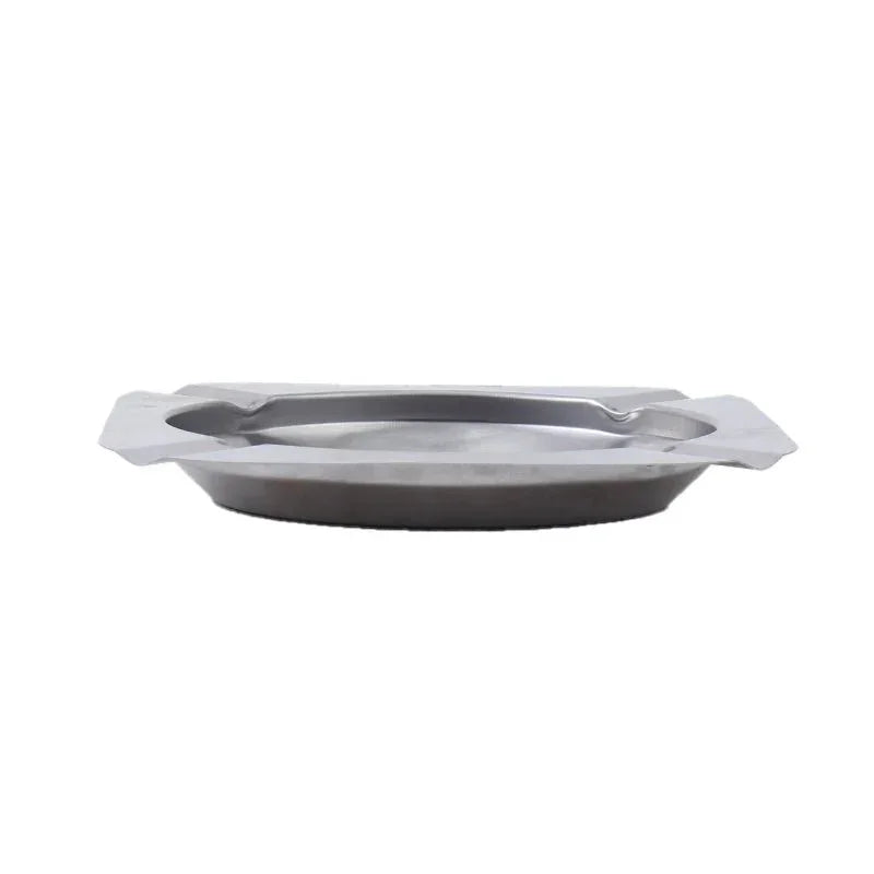 Silver metal ashtray with square edges and round inner basin on white background