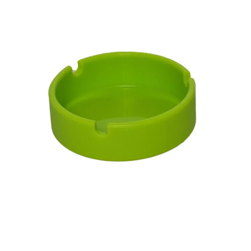 Bright green plastic ashtray with three cigarette rests on white background