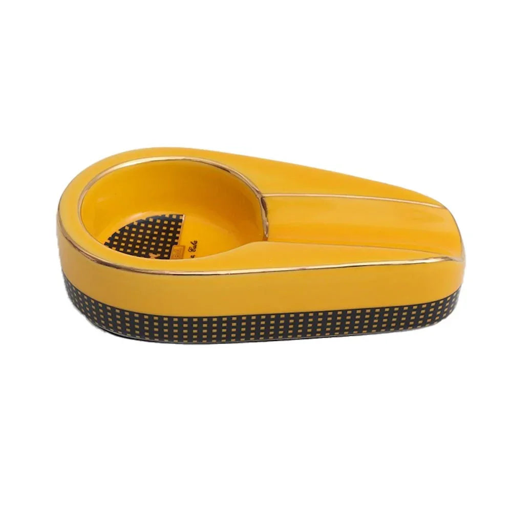 Yellow and black ceramic cigar ashtray with gold trim and checkered pattern