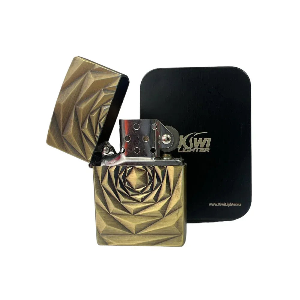 Open brass-colored metal lighter with geometric pattern and black Kiwi Lighter box
