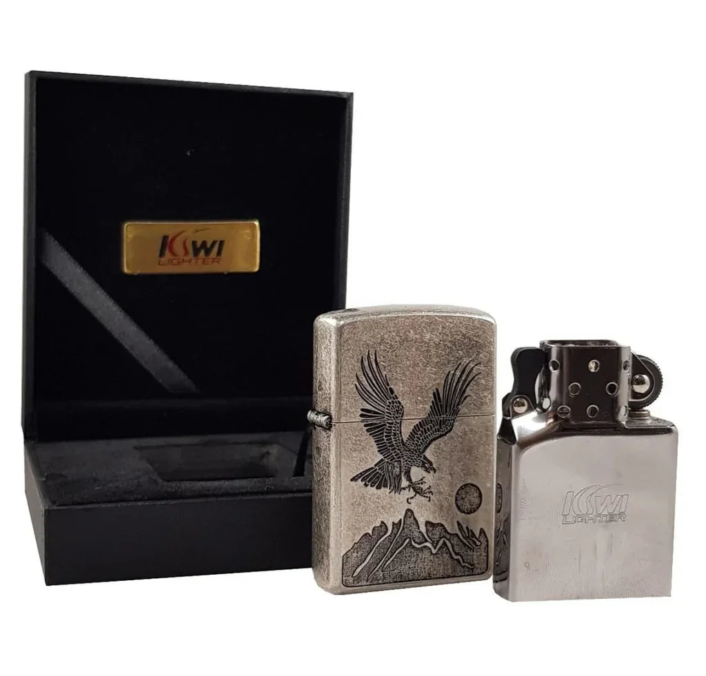 Vintage metal lighter with eagle and mountain design beside open black KSwi Lighter box