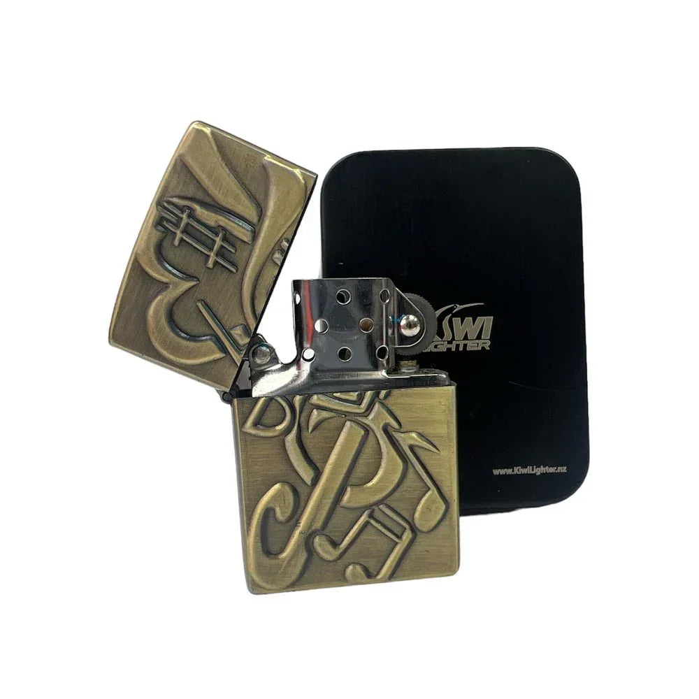 Open brass lighter with embossed music notes and saxophone design next to black Kiwi Lighter case