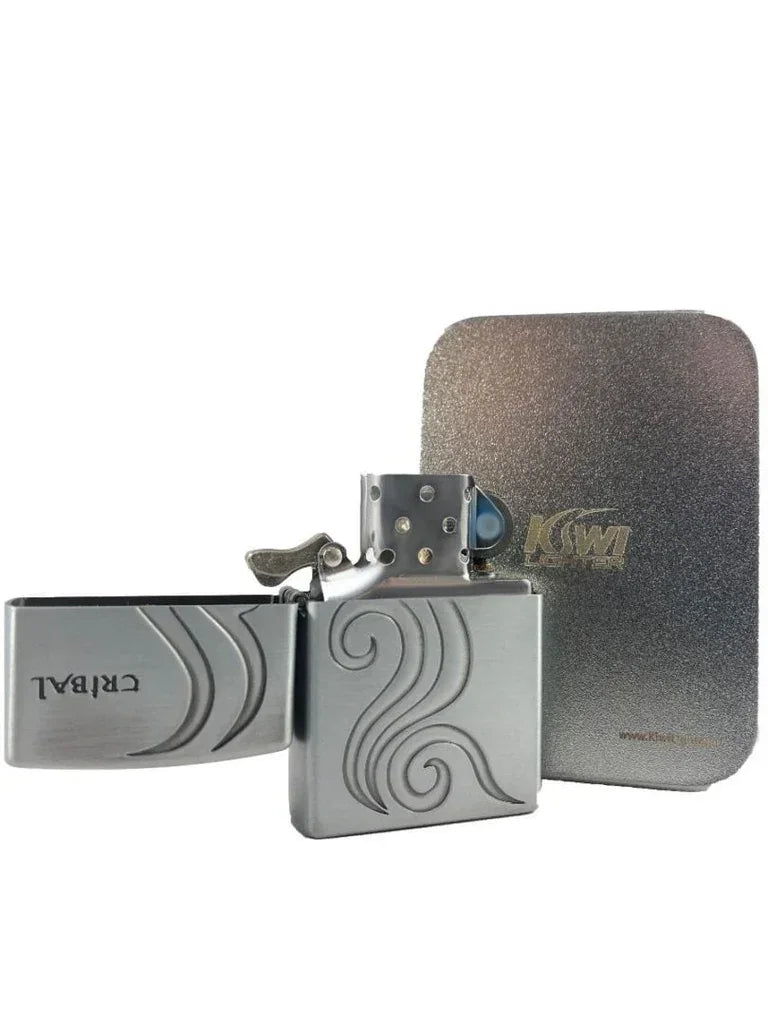 Silver metal flint lighter with engraved swirl design and open lid, next to textured silver case