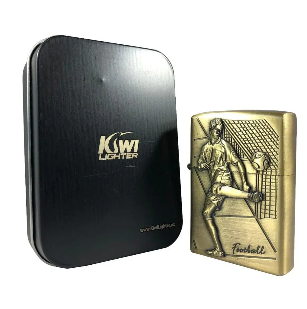 Brass Kiwi Lighter with embossed football player and goal design beside black metal Kiwi Lighter box