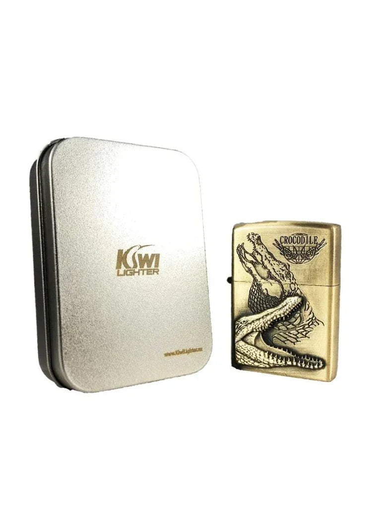 Gold KSwi lighter with detailed crocodile design beside silver KSwi Lighter metal case