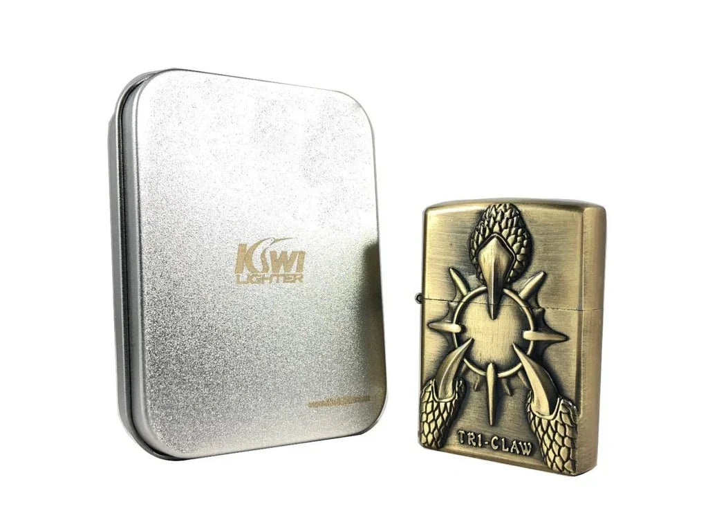 Antique brass Kiwi TR1-Claw lighter with embossed claw design next to silver Kiwi Lighter metal case