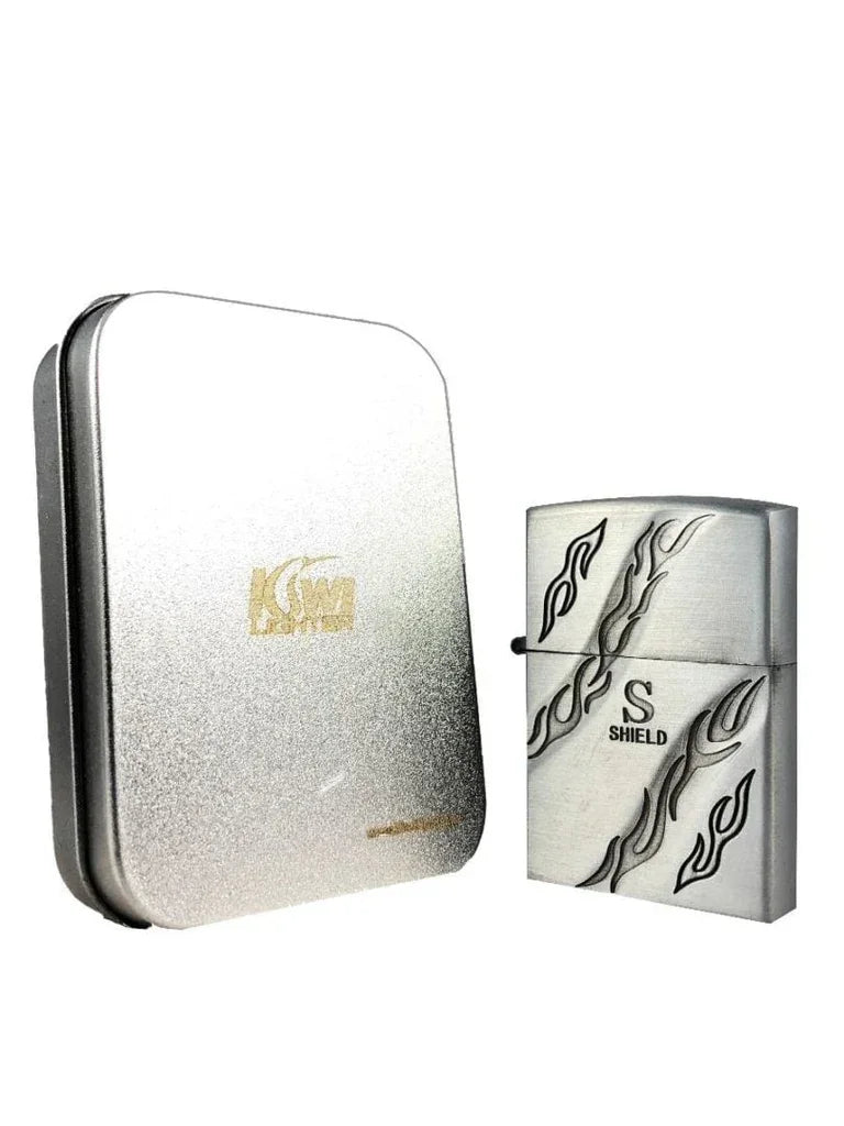 Silver metal lighter with black flame design and Shield logo beside silver metal tin box