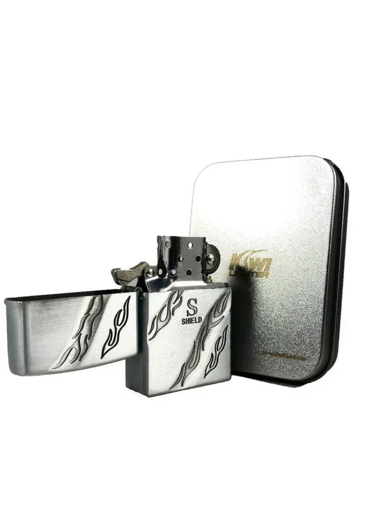 Silver metal flint lighter with flame engravings and S Shield logo, next to a silver case
