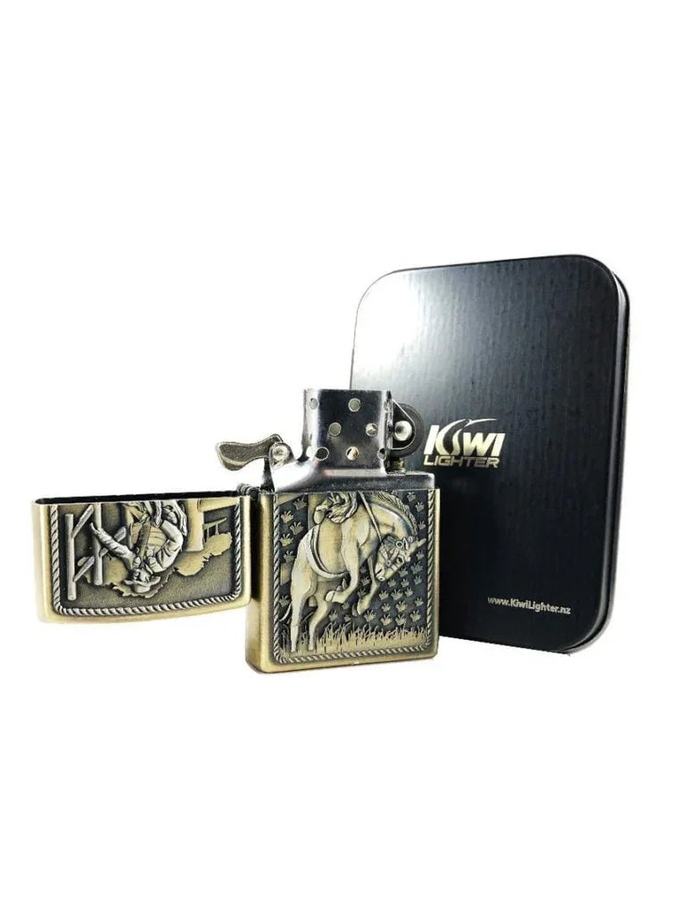 Open vintage-style metal lighter with horse and rider design, beside black Kiwi Lighter tin box