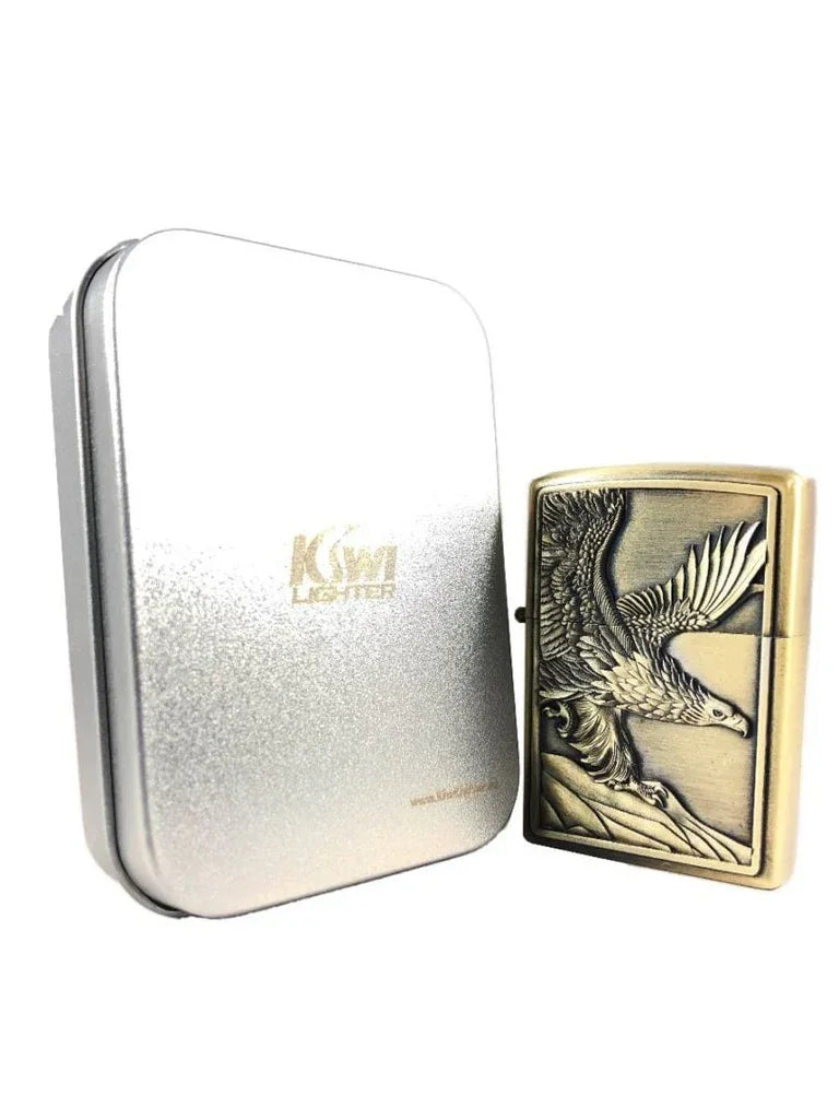Antique brass lighter with detailed eagle engraving next to a silver KW lighter metal case