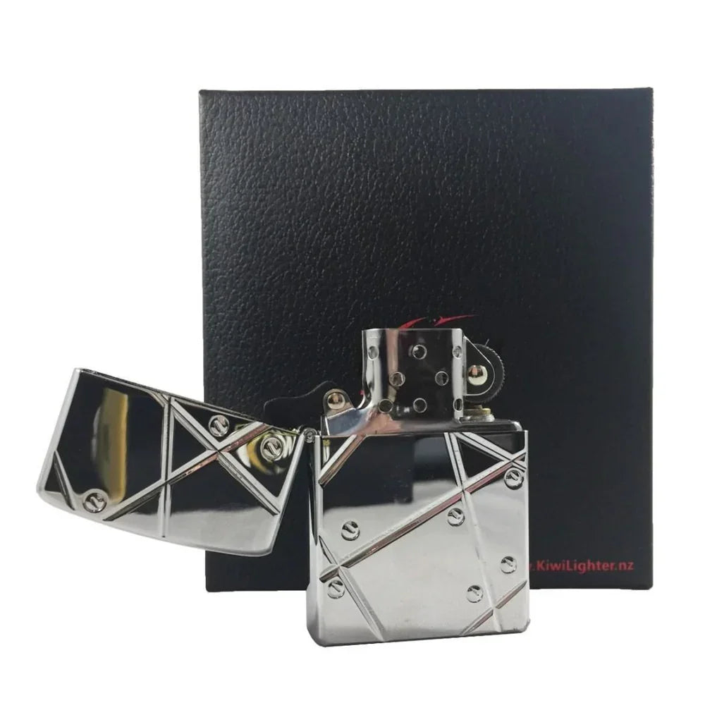 Chrome metal flint lighter with geometric design and screws next to black textured box