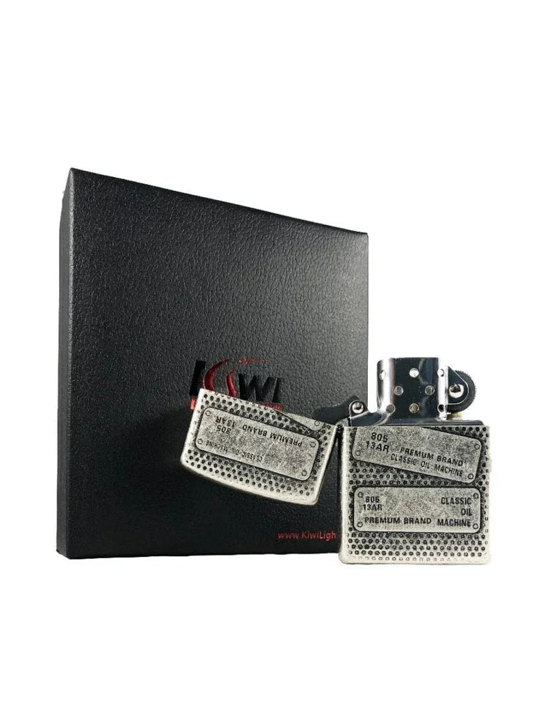 Silver vintage-style metal flint lighter with inscriptions, displayed beside black textured KiwiLight box