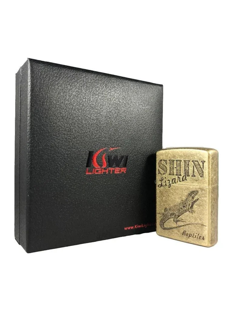 Brass Shin Lizard Reptiles engraved lighter next to black Kiwi Lighter textured gift box