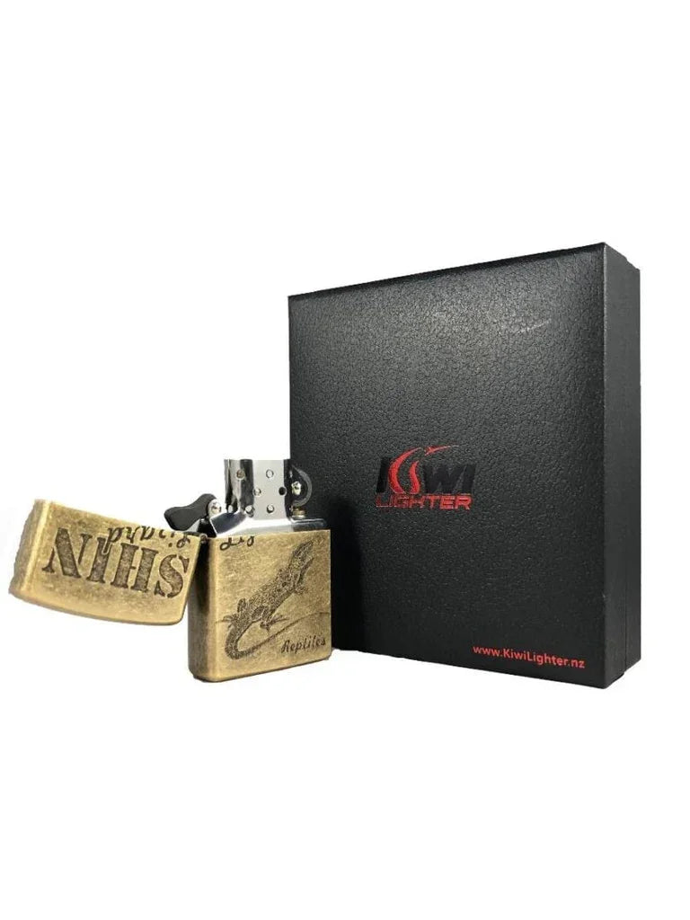 Antique brass-style flip-top lighter with gecko design and black Kiwi Lighter gift box