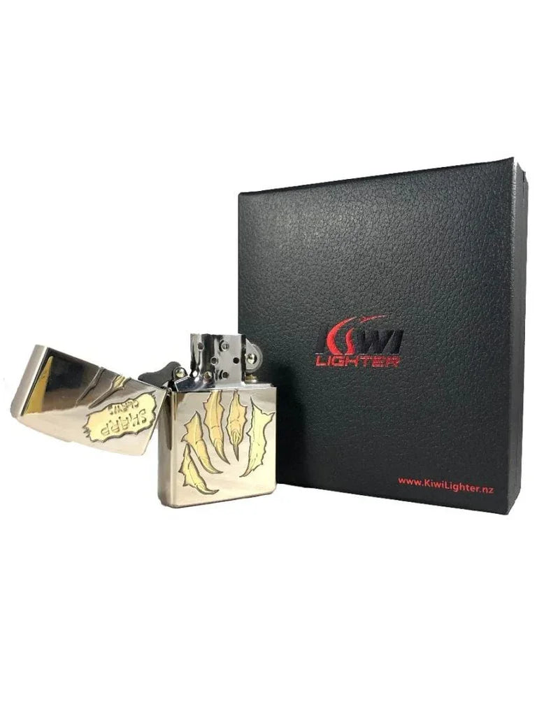 Silver metal flint lighter with claw scratch design and an open lid, beside black Kiwi Lighter gift box