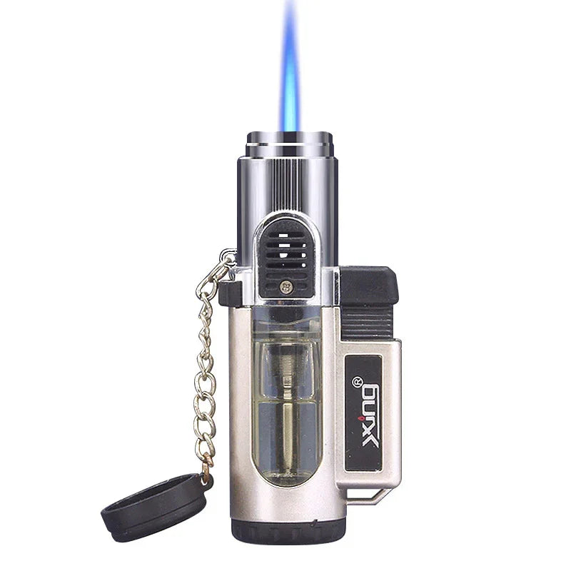 silver and black jet lighter with visible fuel tank and blue flame, attached cap with chain