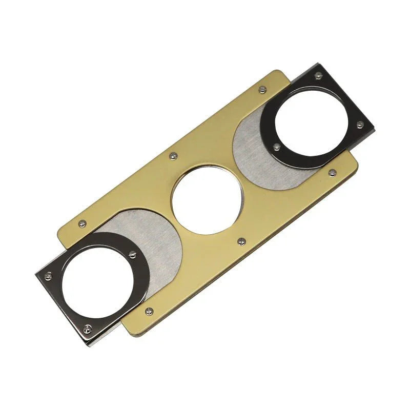 metal cigar cutter with two circular blades and gold and black design on plain white background