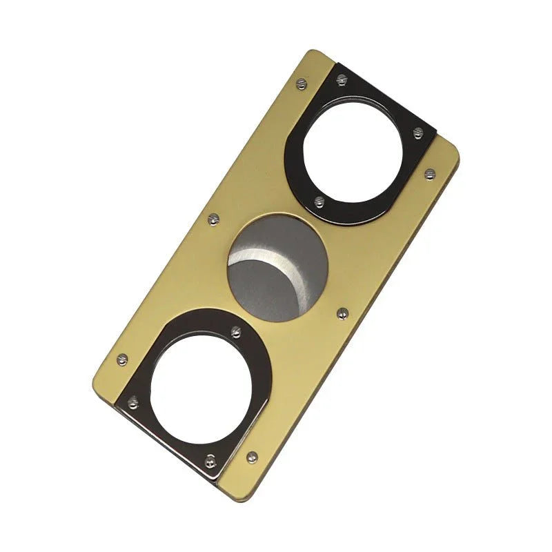 rectangular metal cigar cutter with two circular blades and a gold finish on a white background